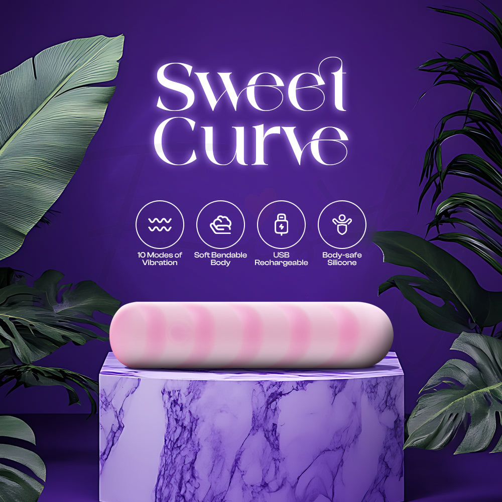 Pink curved vibrator resting on a marble pedestal with tropical leaves behind it.