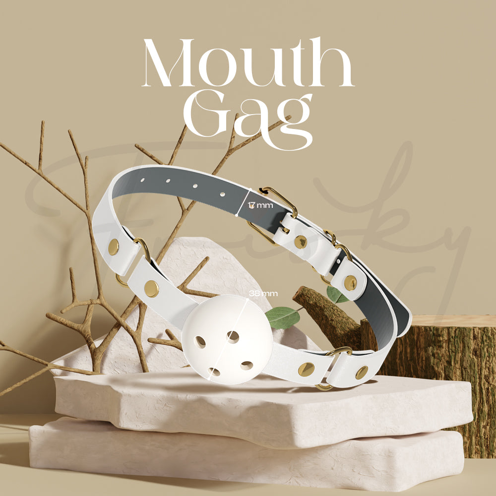 White and gold mouth gag displayed on a wooden stand with soft neutral background.