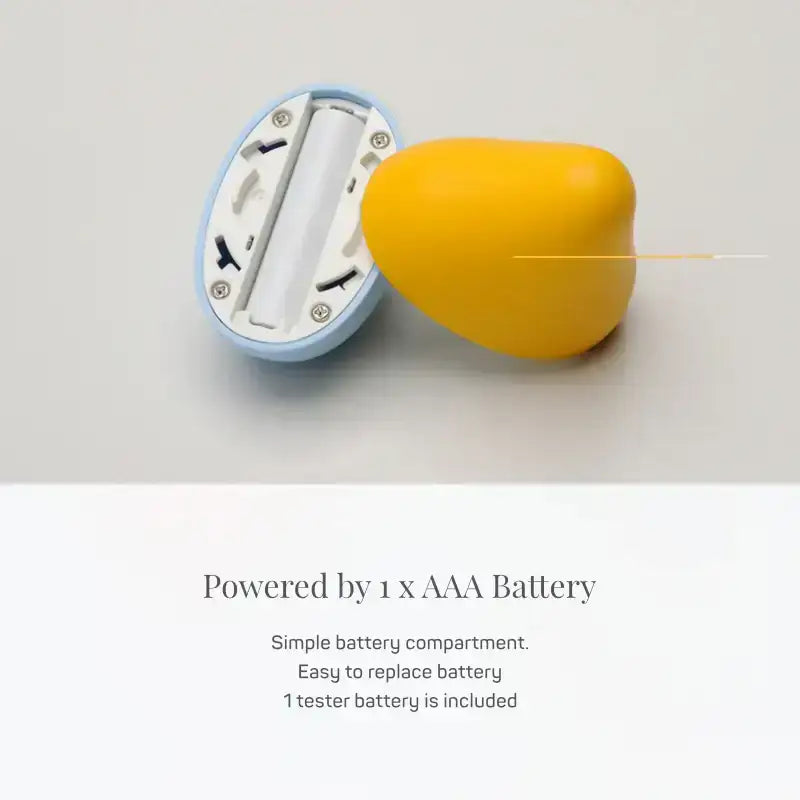 Yellow fruit-shaped object with a battery compartment on a light gray background