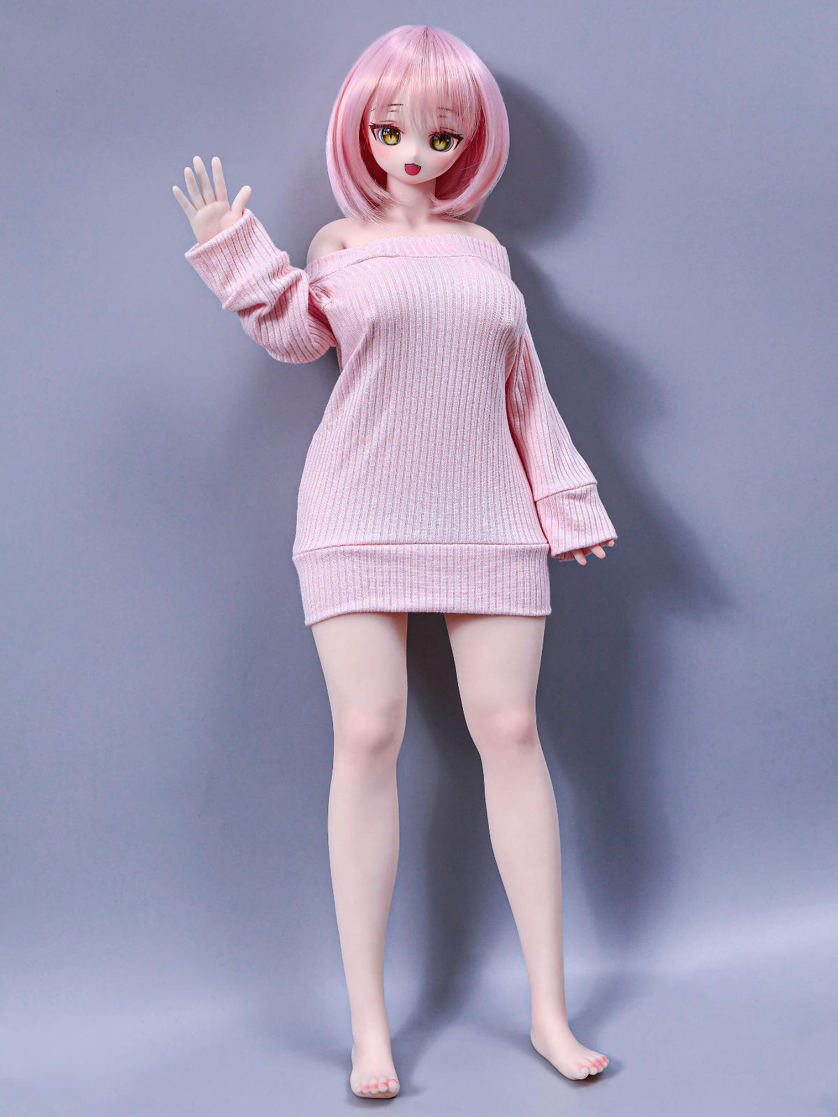 CLIMAX DOLL Mini J60cm P Hybrid - Azami (Cinnamon) full-body standing pose with one hand raised in a friendly wave, pale pink sweater dress, short pink bob