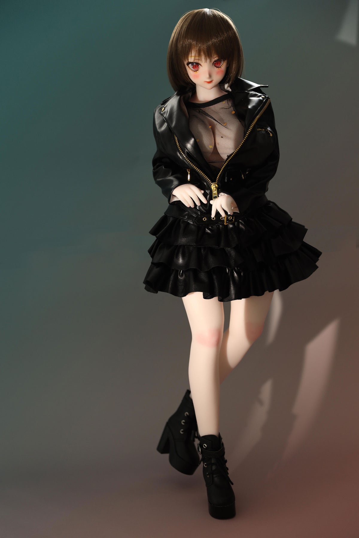 CLIMAX DOLL Mini J60cm P Hybrid - Zella (White) - Standing pose with both hands clasped in front, black ruffled jacket-dress and black boots, shy gentle expression, teal-green gradient backdrop.