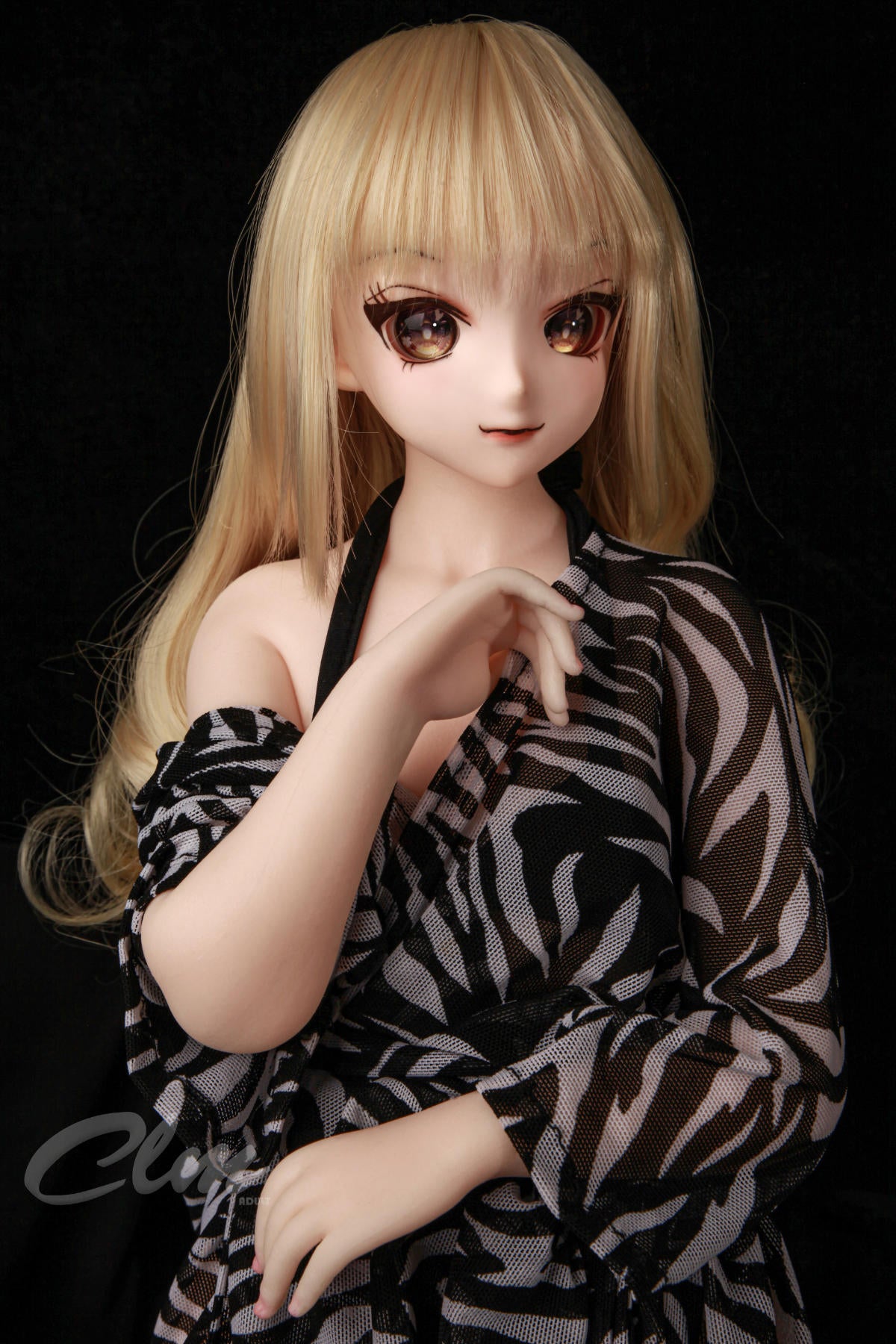 CLIMAX DOLL Mini J60cm XS Hybrid - Nagisa (Cinnamon) close-up portrait, long wavy honey-blonde hair, large brown anime eyes, sheer zebra-print robe slipping off one shoulder, hand resting near her collarbone, black studio backdrop