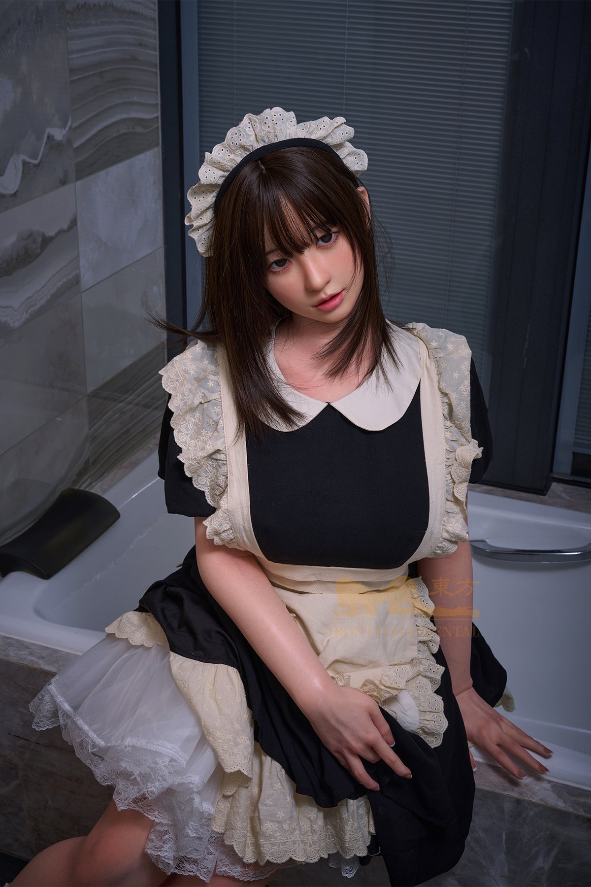 Irontech Doll 158T Oriental Series Silicone – Yui sitting elegantly on side of a bathtub in her maid costume, showing detailed facial features and lifelike pose.