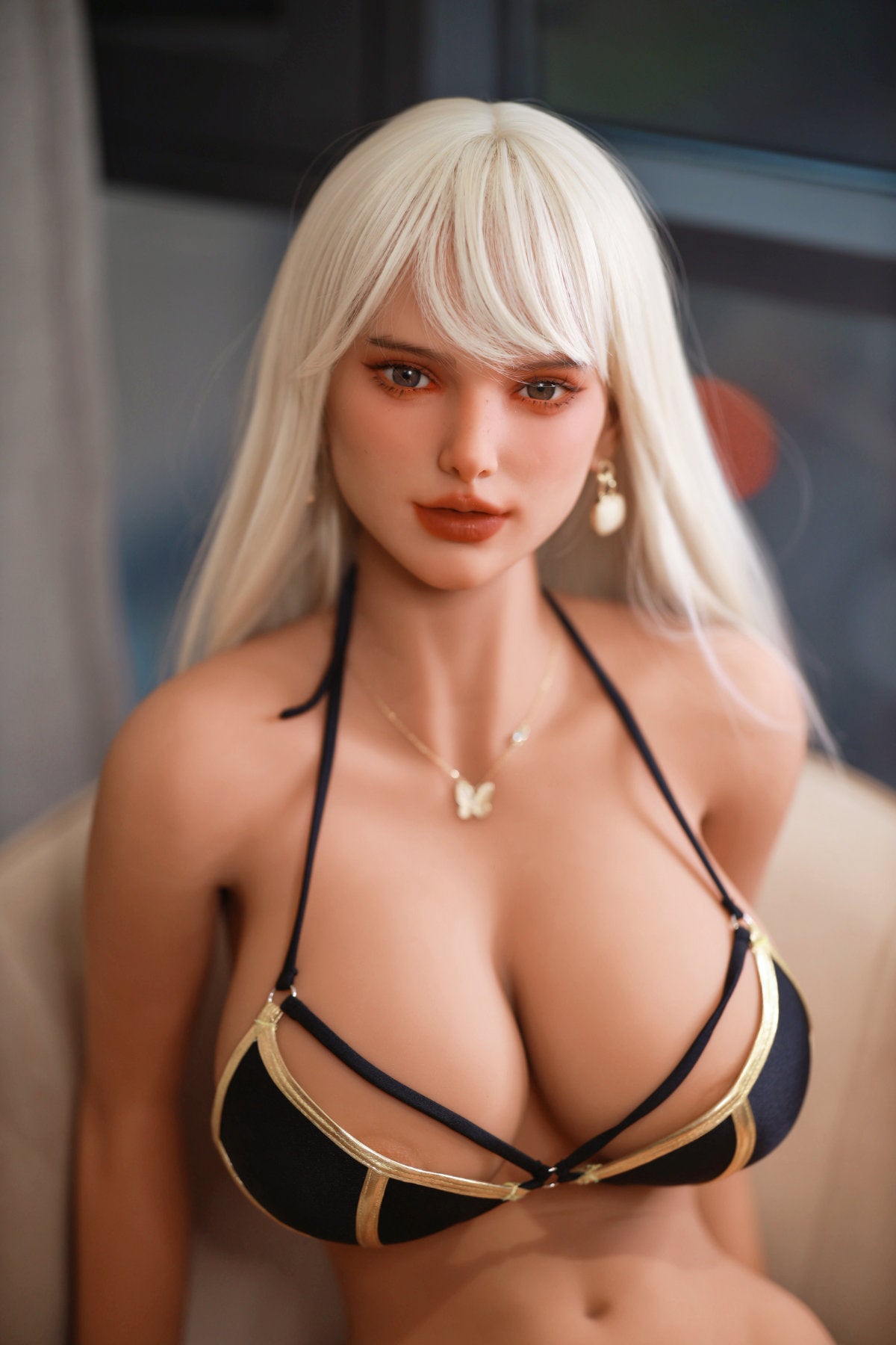 Fire Doll 166 cm E TPE - Hedi close-up upper body shot in black strappy bikini top with gold pendant necklace, long white blonde hair, neutral background