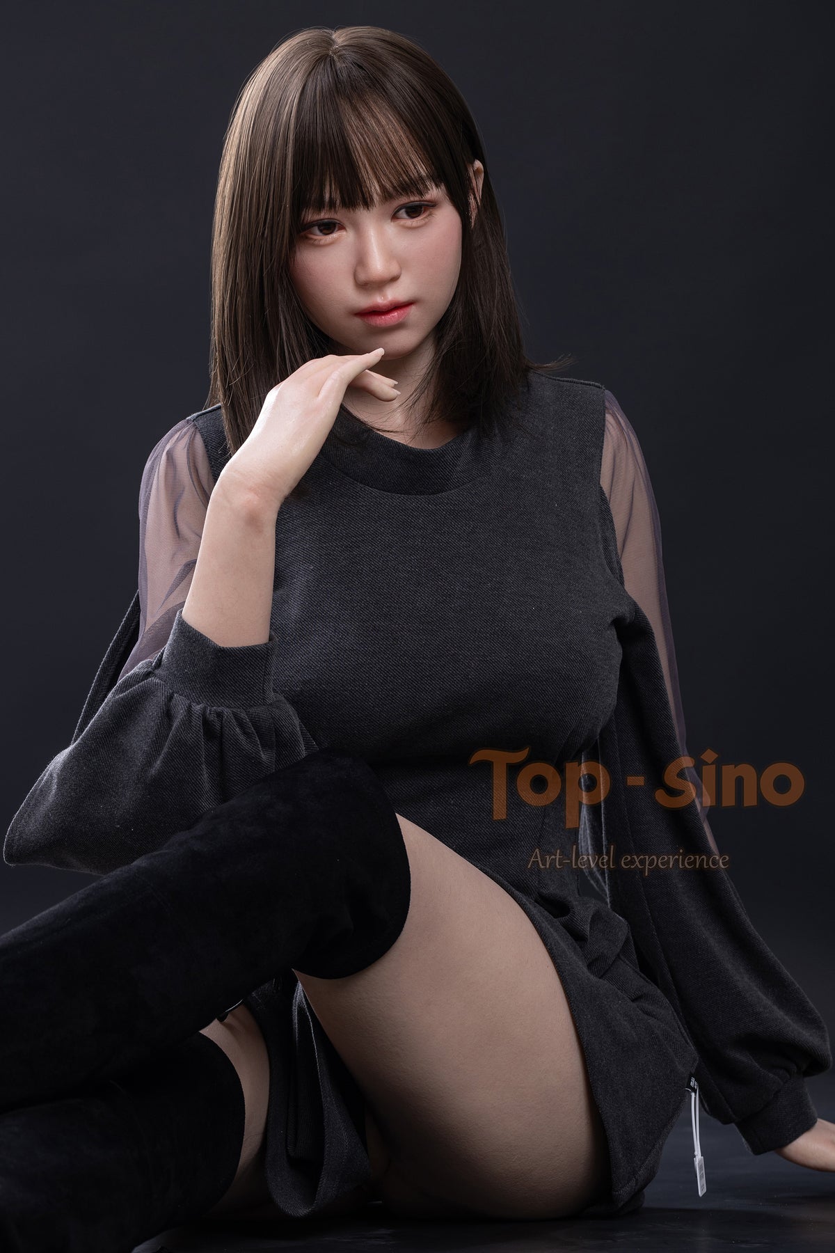 Top Sino 167 cm Platinum Silicone Recreated Series - Miju V2 (RRS+) wearing a gray outfit with sheer sleeves sitting above the table, against a dark background.