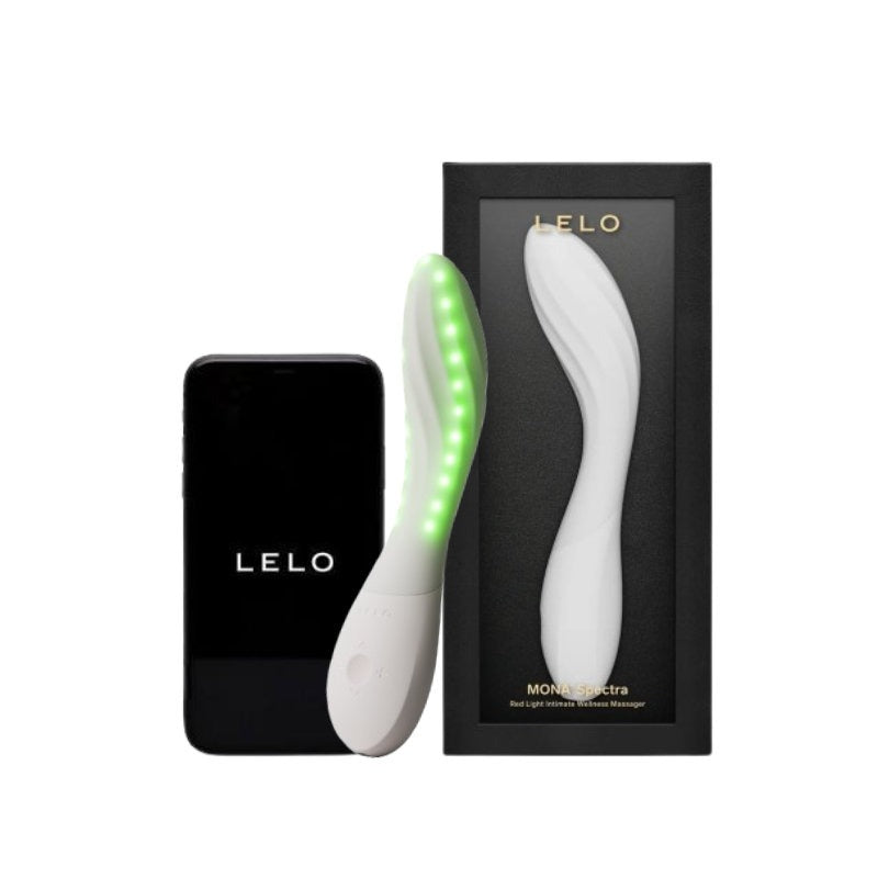 LELO Monstera light therapy wand shown with its black charging case and retail box on a white background. The wand is white with a glowing green LED light strip along one side.