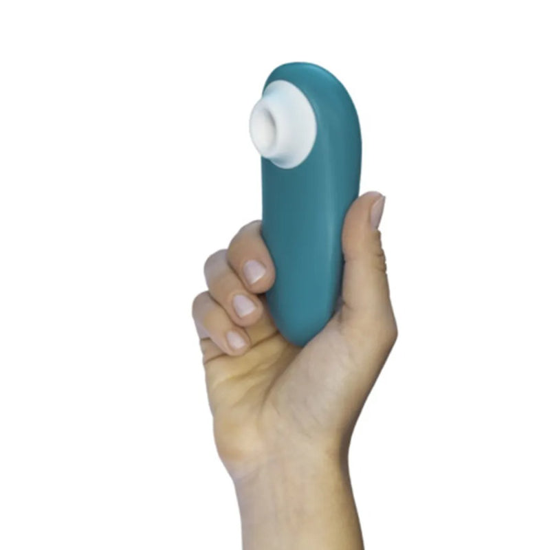 Hand holding the turquoise Womanizer Starlet 3 to show its compact size and white opening