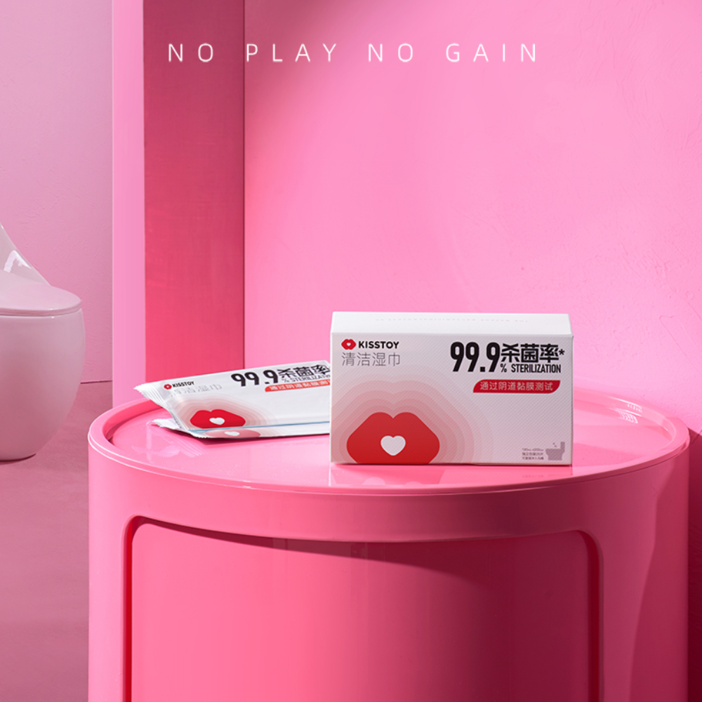 Kisstoy companion kit box resting on a round pink side table against a pink wall