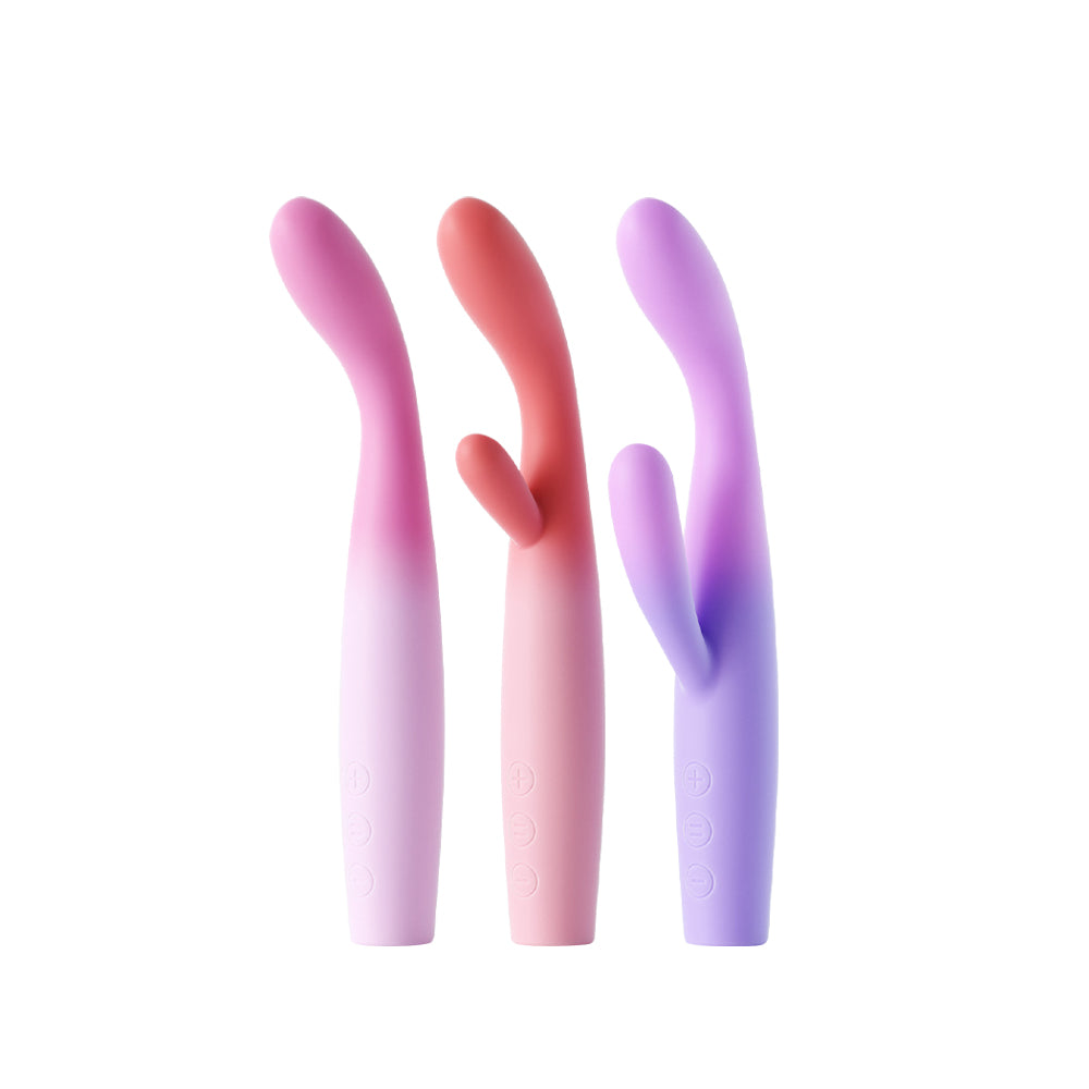 Three Power Bloom rabbit-style vibrators in light pink, red, and purple, shown side-by-side against a neutral white background.