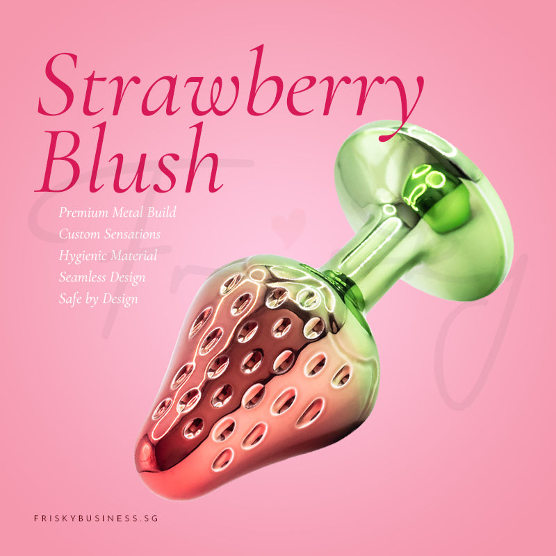 Strawberry-shaped metal plug displayed with fresh strawberry-inspired design and green base