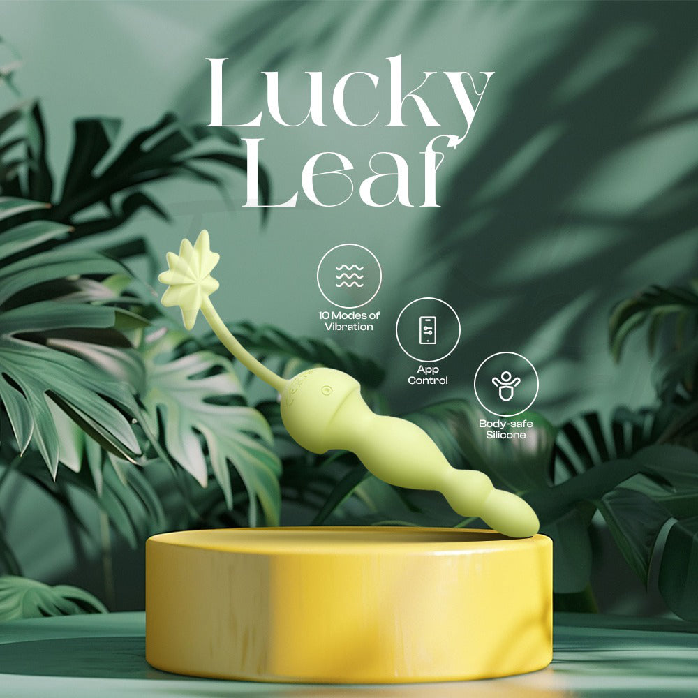 Green silicone pleasure wand displayed on pedestal with botanical leaf theme
