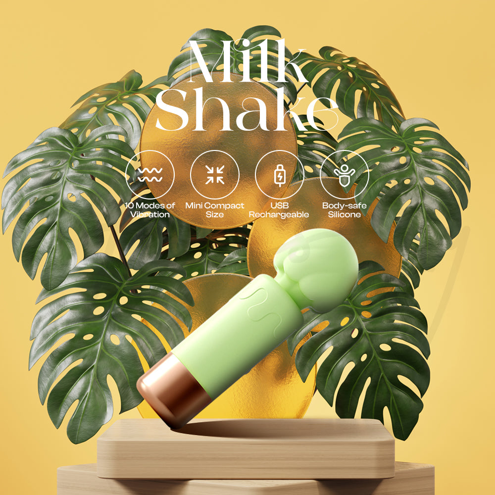 Mint-green mini vibrator displayed among lush green leaves with warm soft lighting