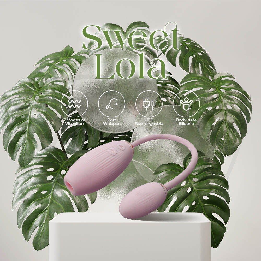 Sweet Lola dual-egg vibrator displayed among green leaves showcasing soft pink color.