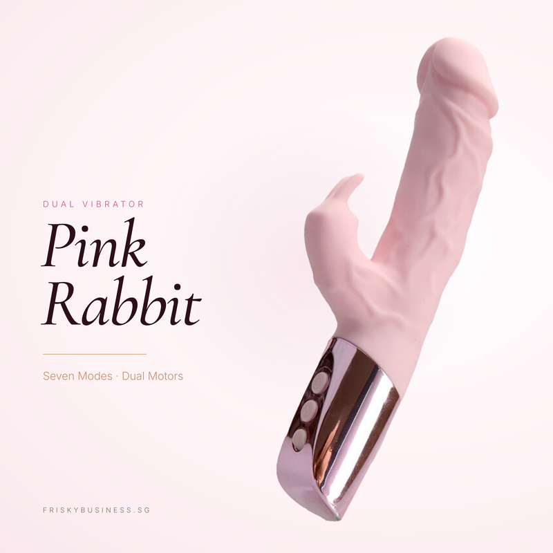 A pink rabbit-shaped dual vibrator with a metallic rose gold base, shown against a pale pink background with text reading 'Pink Rabbit' and 'Dual Vibrator'.