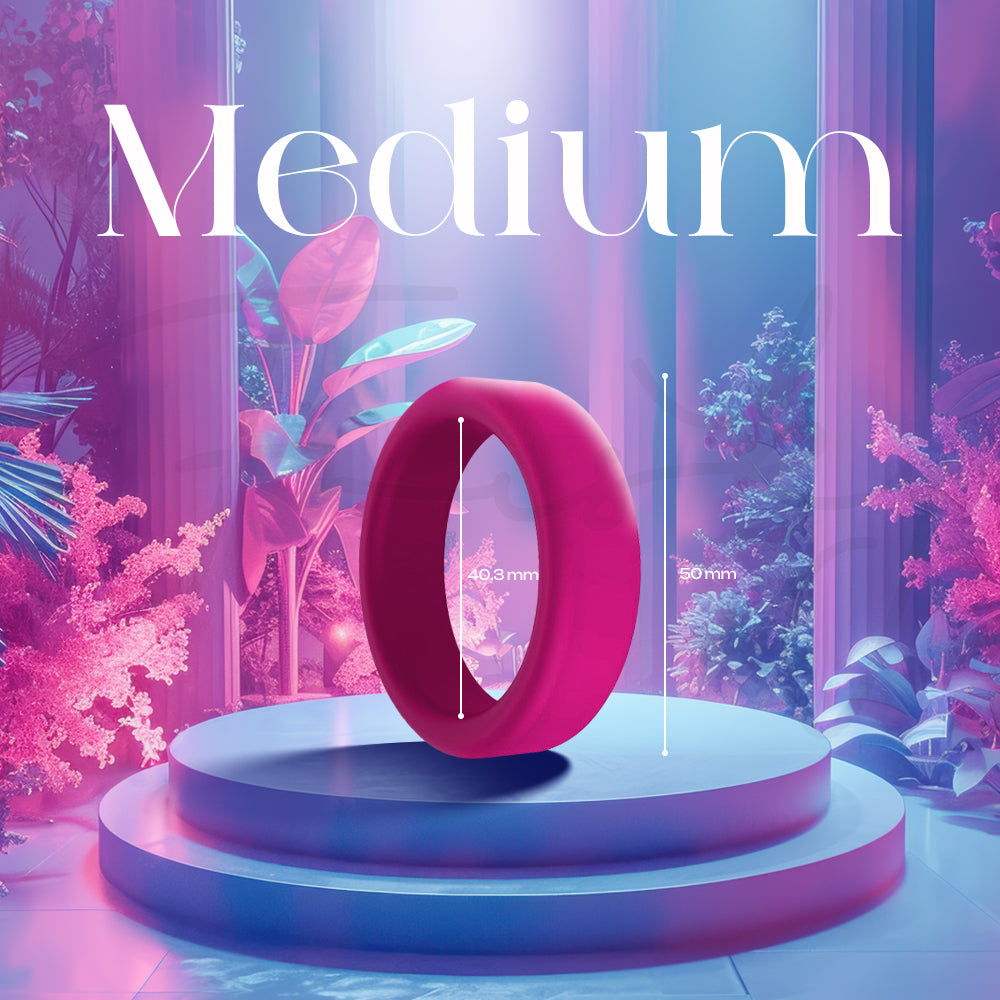 A medium pink silicone ring standing on a decorative illuminated pedestal