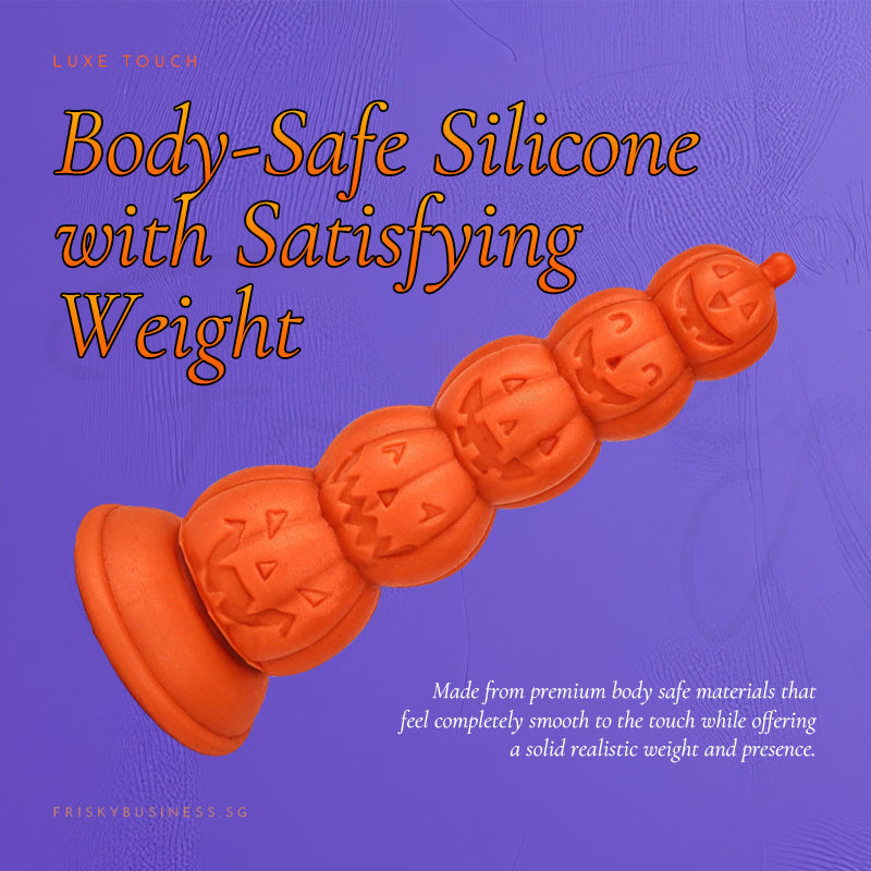 Body-safe silicone graphic with the orange pumpkin plug lying on its side on purple