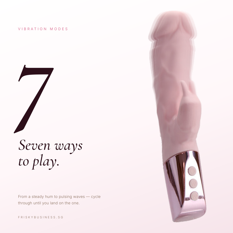 A pink silicone vibrator with a metallic rose-gold base and three control buttons, shown on a white background with promotional text reading '7 Seven ways to play.' and 'Vibration modes' by Frisky Business.