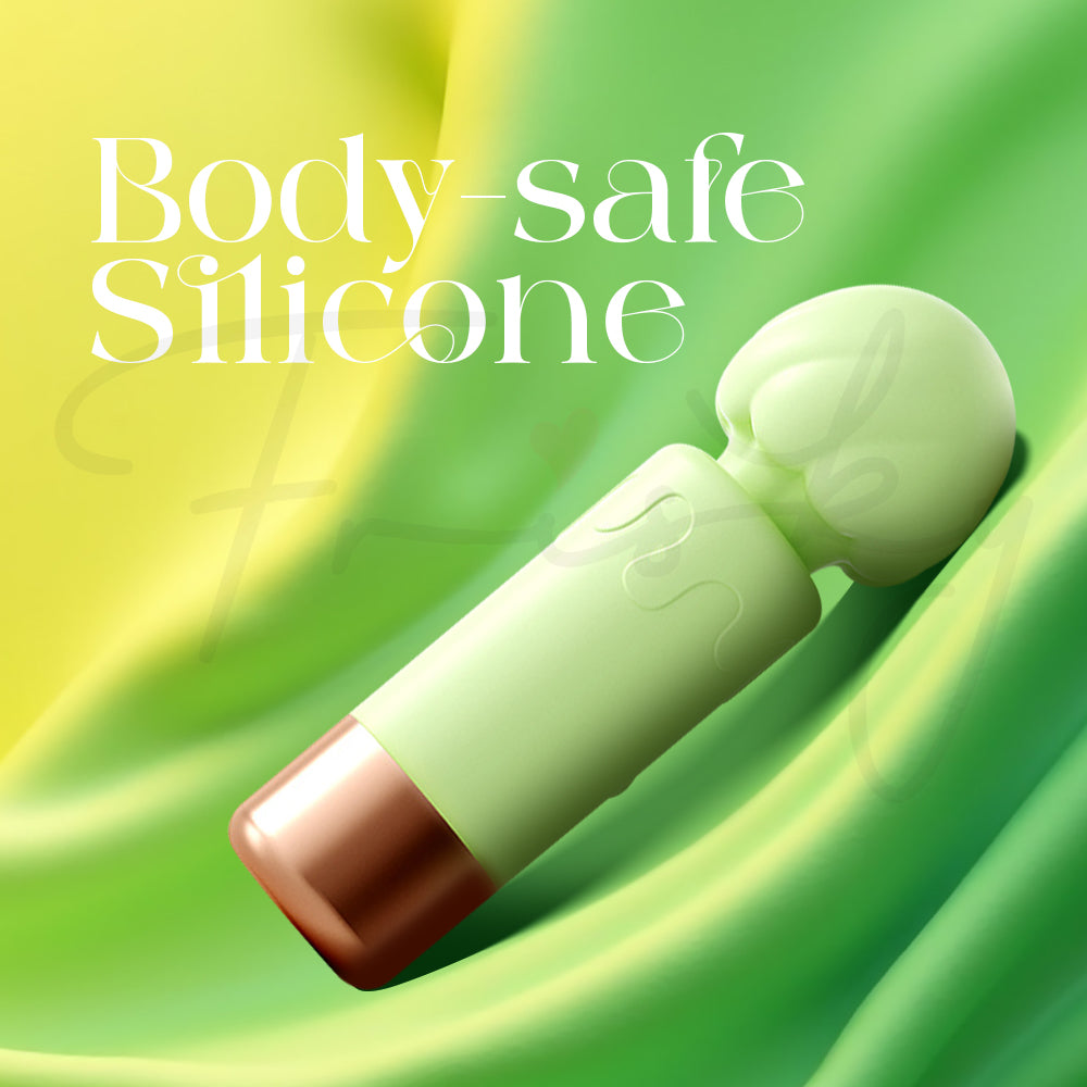 Soft silicone green vibrator against a flowing fabric backdrop highlighting body-safe material.