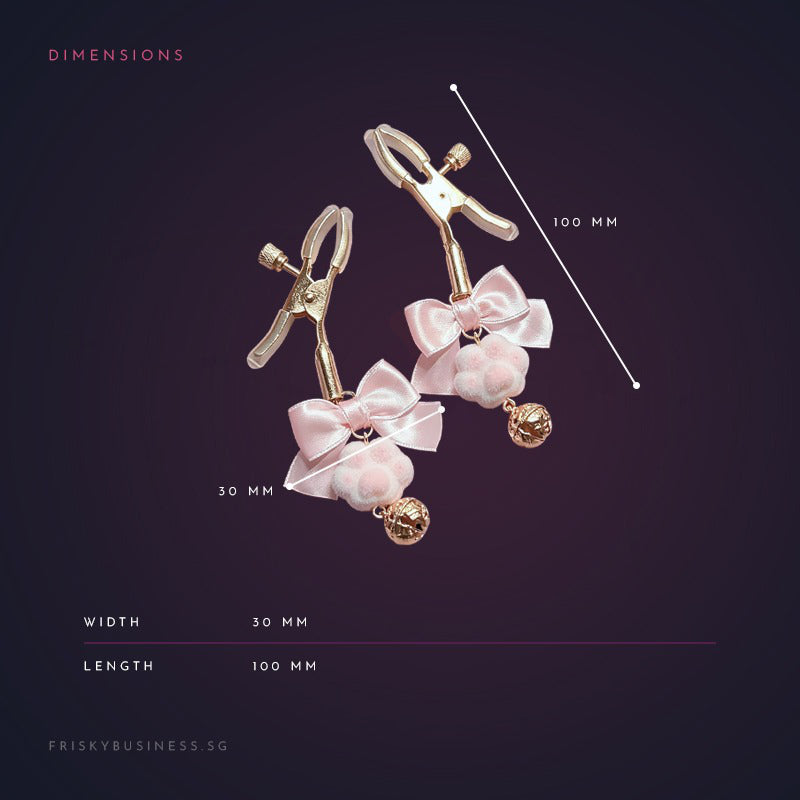 nipple clamps with pink bows and gold accents on a dark background with measurements.