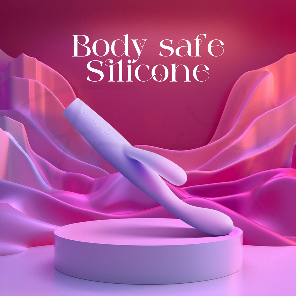 A lavender vibrator resting on a pedestal against soft, wavy purple silk, labeled "Body-safe Silicone" to emphasize material quality.