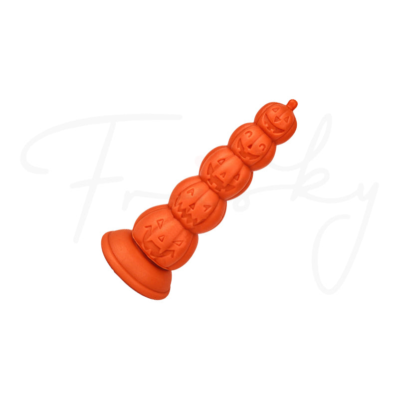 Orange pumpkin-segment plug resting at a diagonal angle on a plain white background