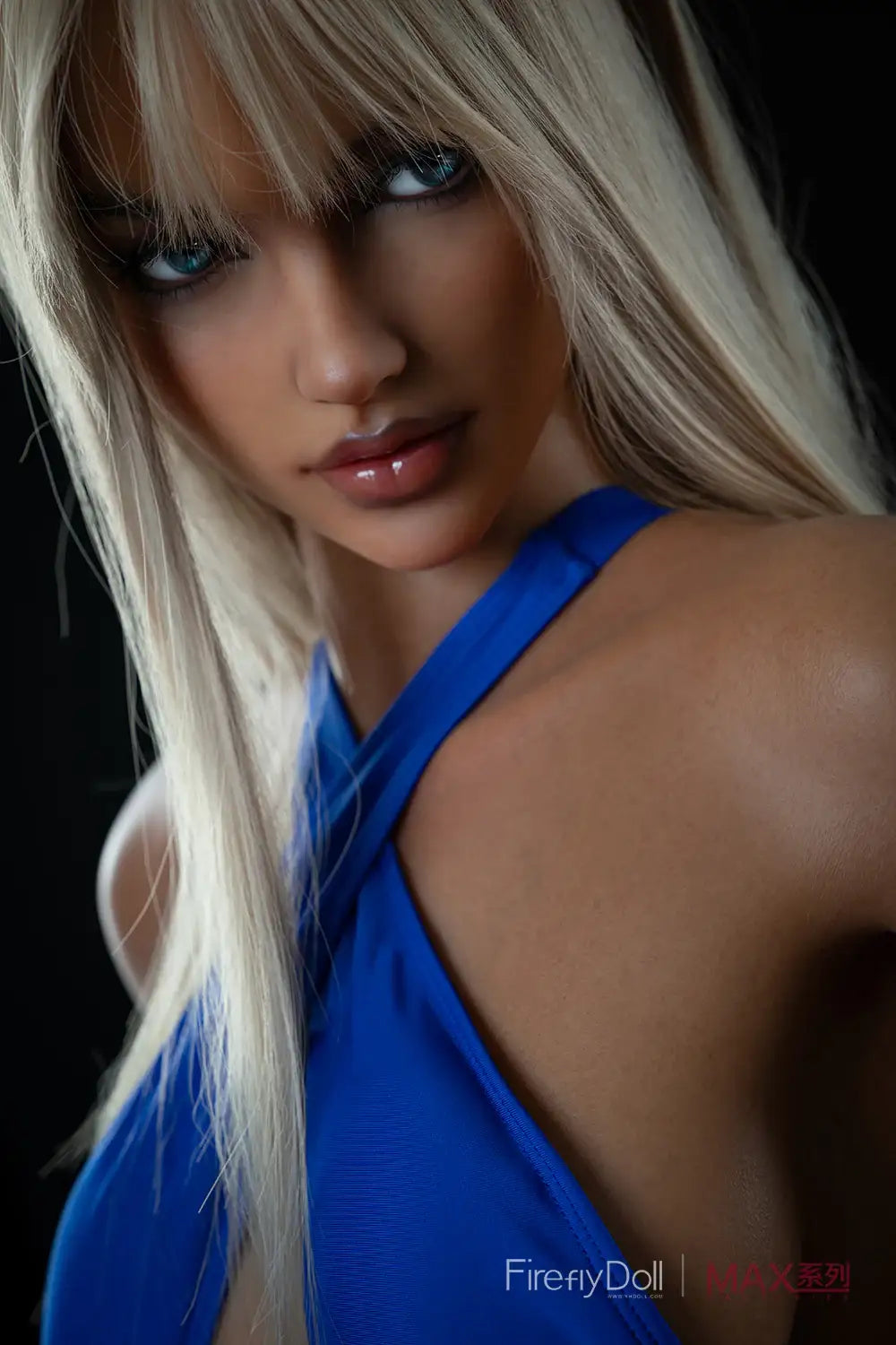Close-up portrait of Firefly Diary Doll 165 cm Max Series Silicone – Mary V3 with long blonde hair, smoky eye makeup, and glossy lips, wearing a blue cross-strap bodysuit against a dark background.