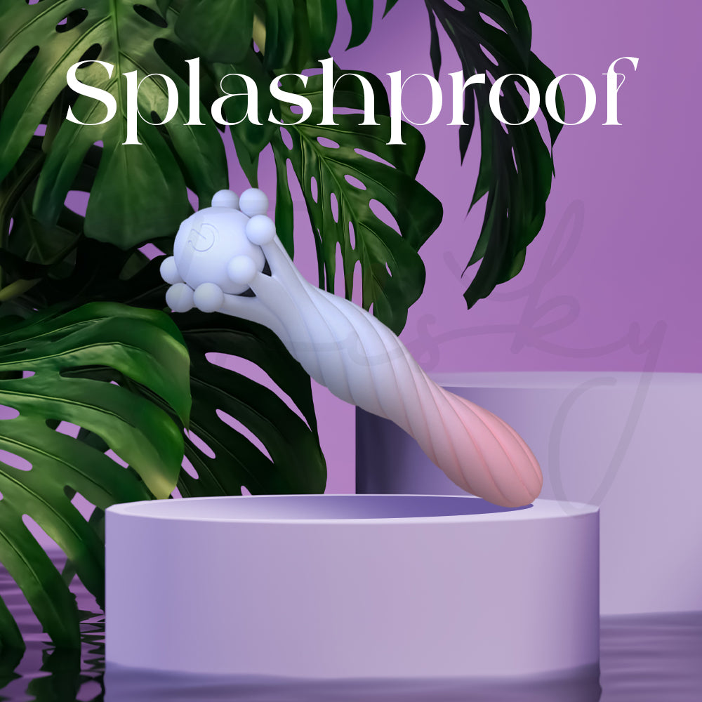 Splashproof silicone vibrator displayed with tropical leaves and water-inspired purple backdrop