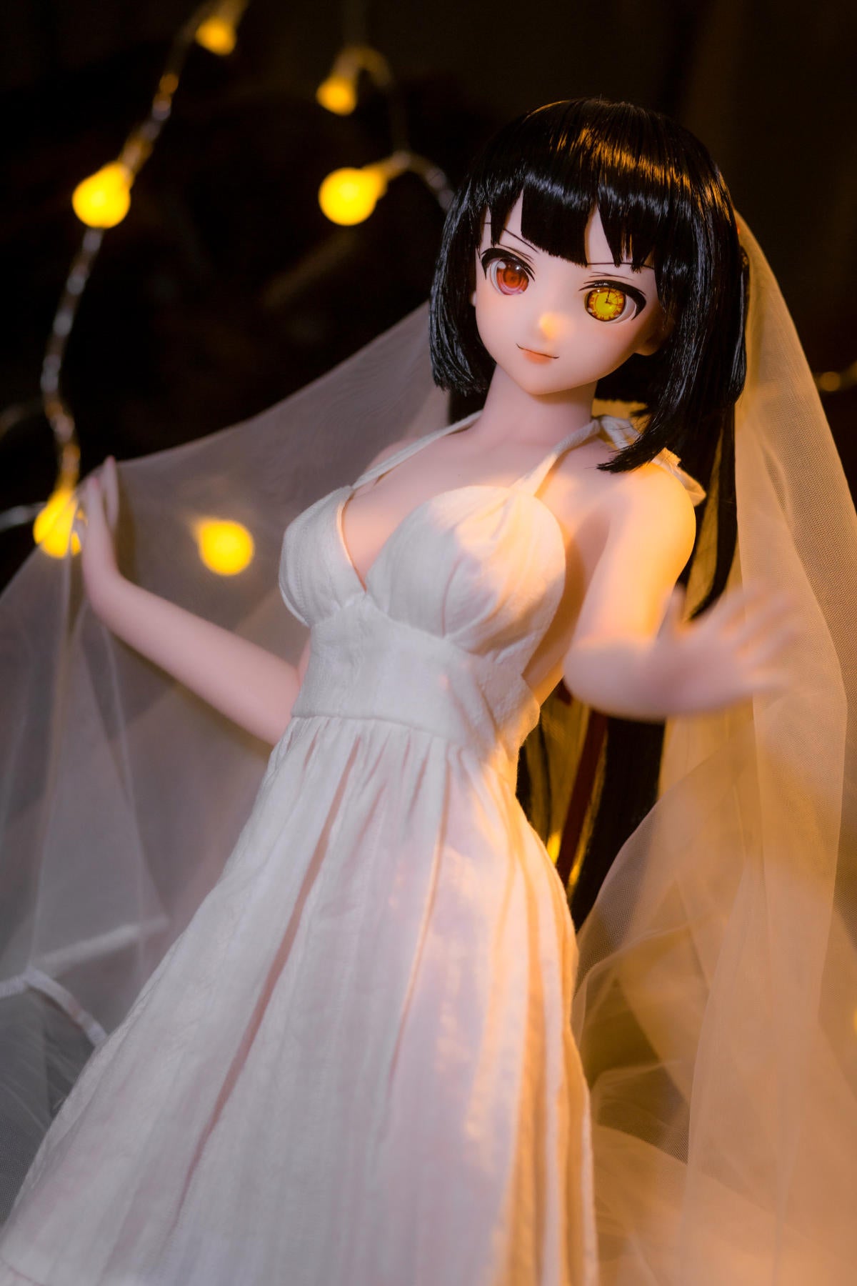 CLIMAX DOLL Mini J60 cm Hybrid - Kurumi (Cinnamon) - Close-up bridal portrait with long black hair, golden clock-style eye and sheer white veil, white gown, fairy-light bokeh on a dark backdrop.