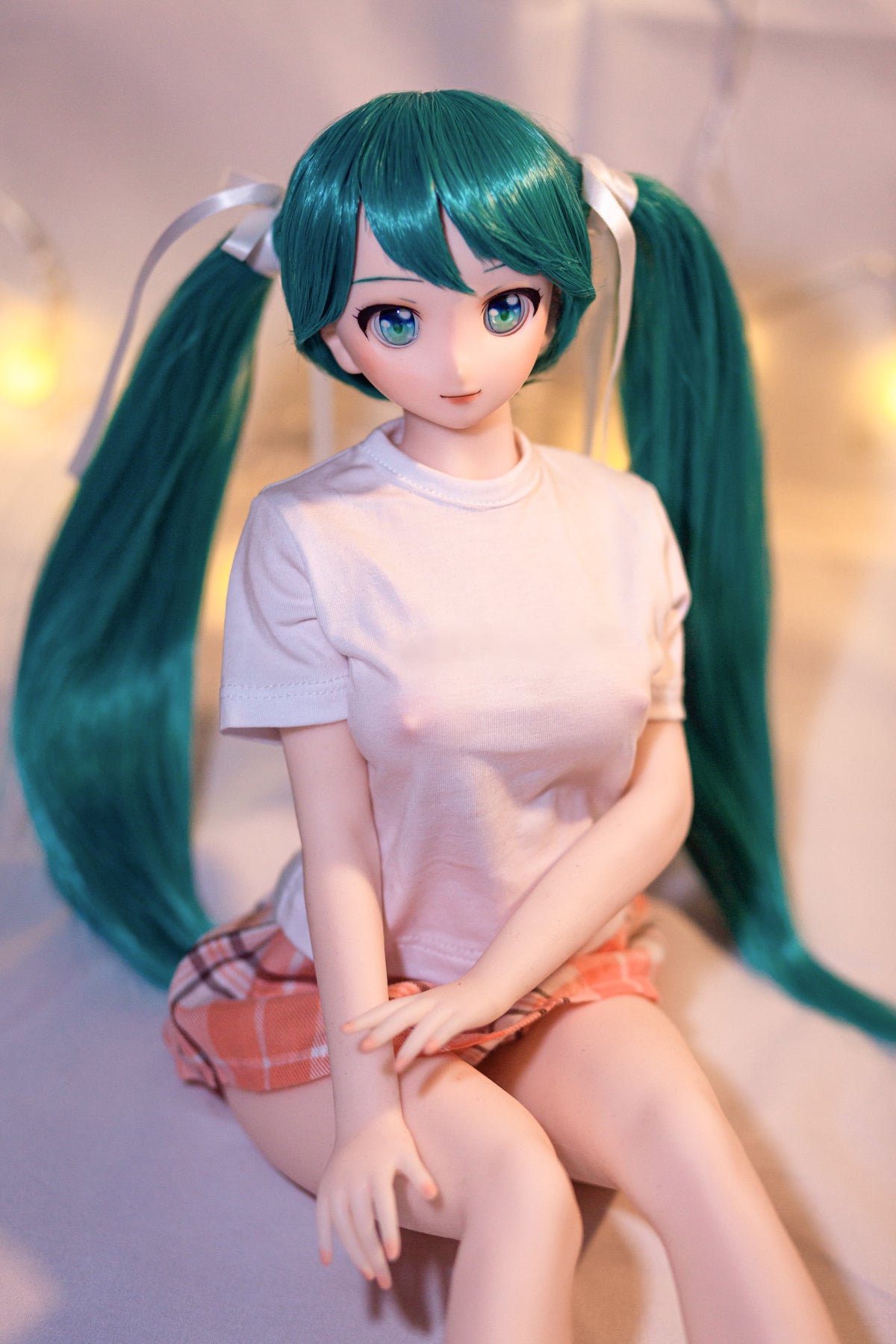 CLIMAX DOLL Mini J60 cm Hybrid - Miku (Cinnamon) - Bright close-up facing the camera, long teal twin tails over her shoulders, white tee, soft pale background.