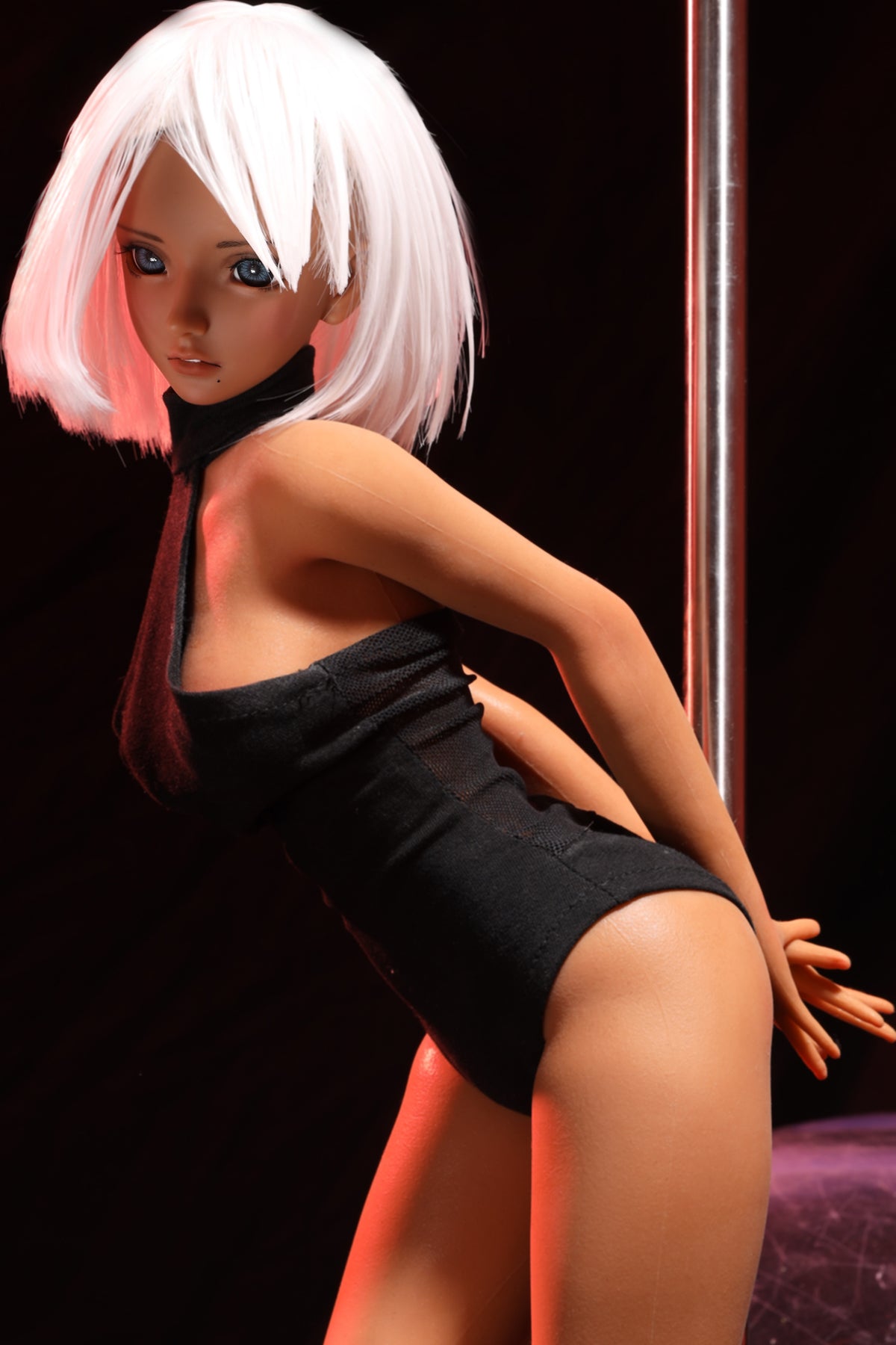 CLIMAX DOLL Mini J60 cm Hybrid - Shirley (Suntan) – leaning pose against a dance pole in black bodysuit