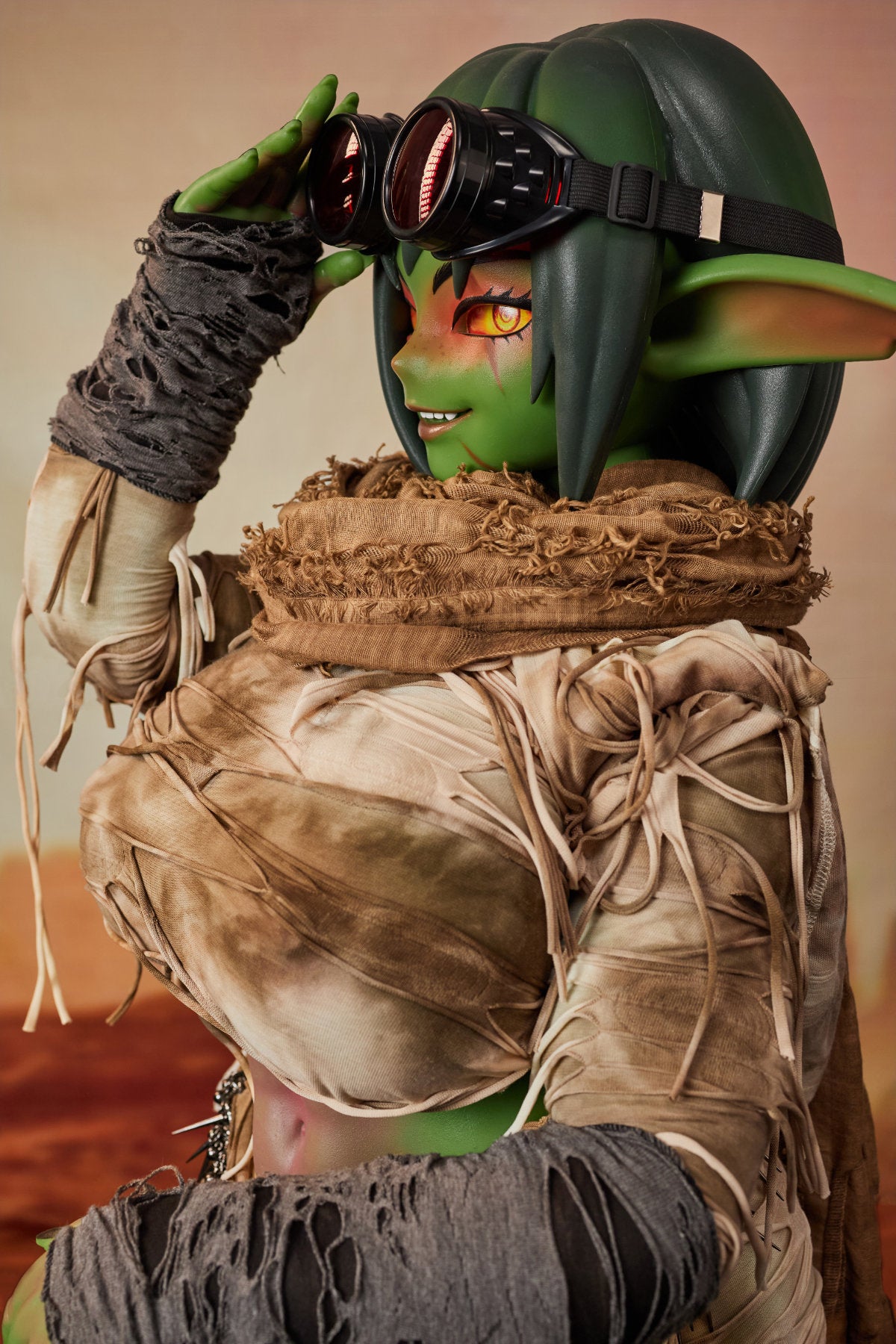 CLIMAX DOLL ULW SiF120 cm Silicone - Barza (Green) upper body front view in tattered tan wrap outfit, short green hair, desert red background
