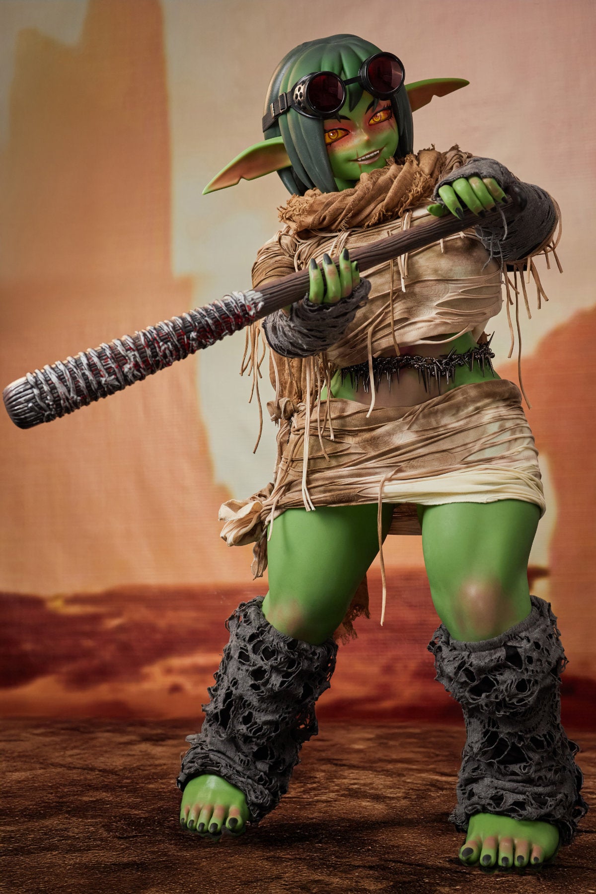 CLIMAX DOLL ULW SiF120 cm Silicone - Barza (Green) full body side view in tattered tan wrap outfit, short green hair, desert red background
