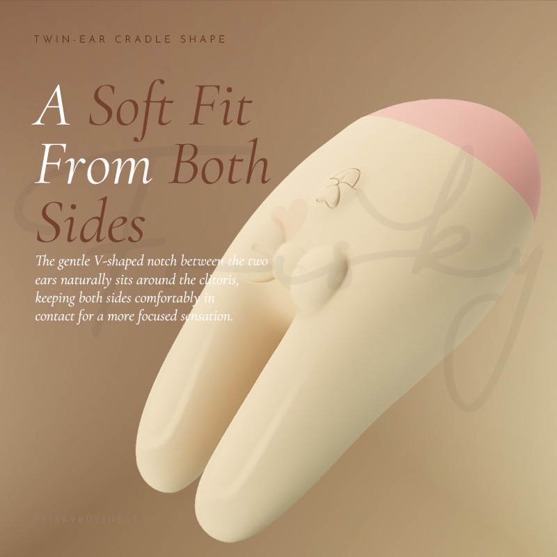 Vibrator shown nestled against a tan backdrop highlighting its dual-ear shape