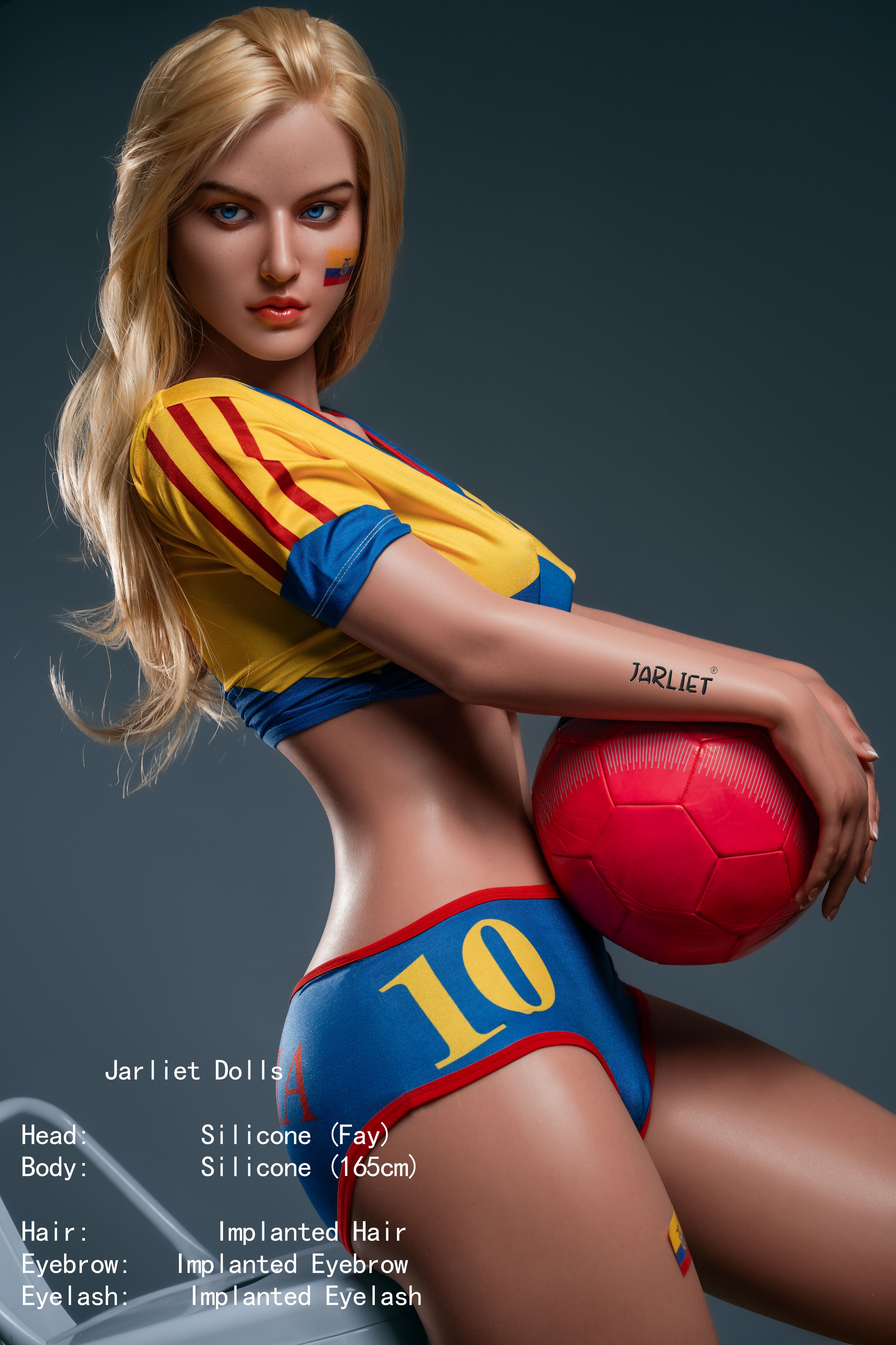 Side profile of the 165 cm silicone Fay doll leaning forward, showcasing her athletic build and soccer uniform, with a red soccer ball held against her hip.