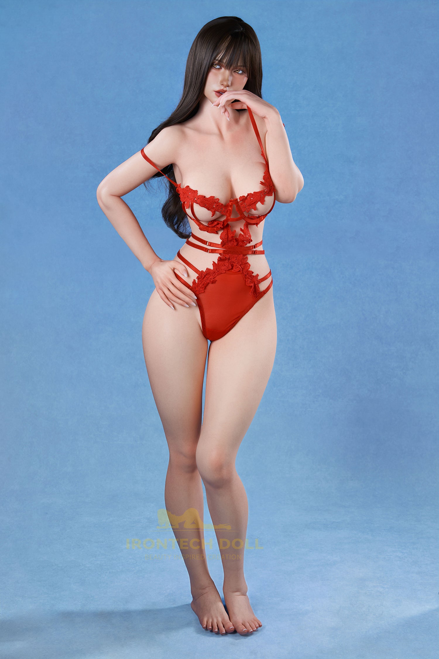 Irontech Doll 166 cm 2.0 E Silicone - Molly reclining on a white star-patterned pillow, wearing a red lace bodysuit against a solid blue background.
