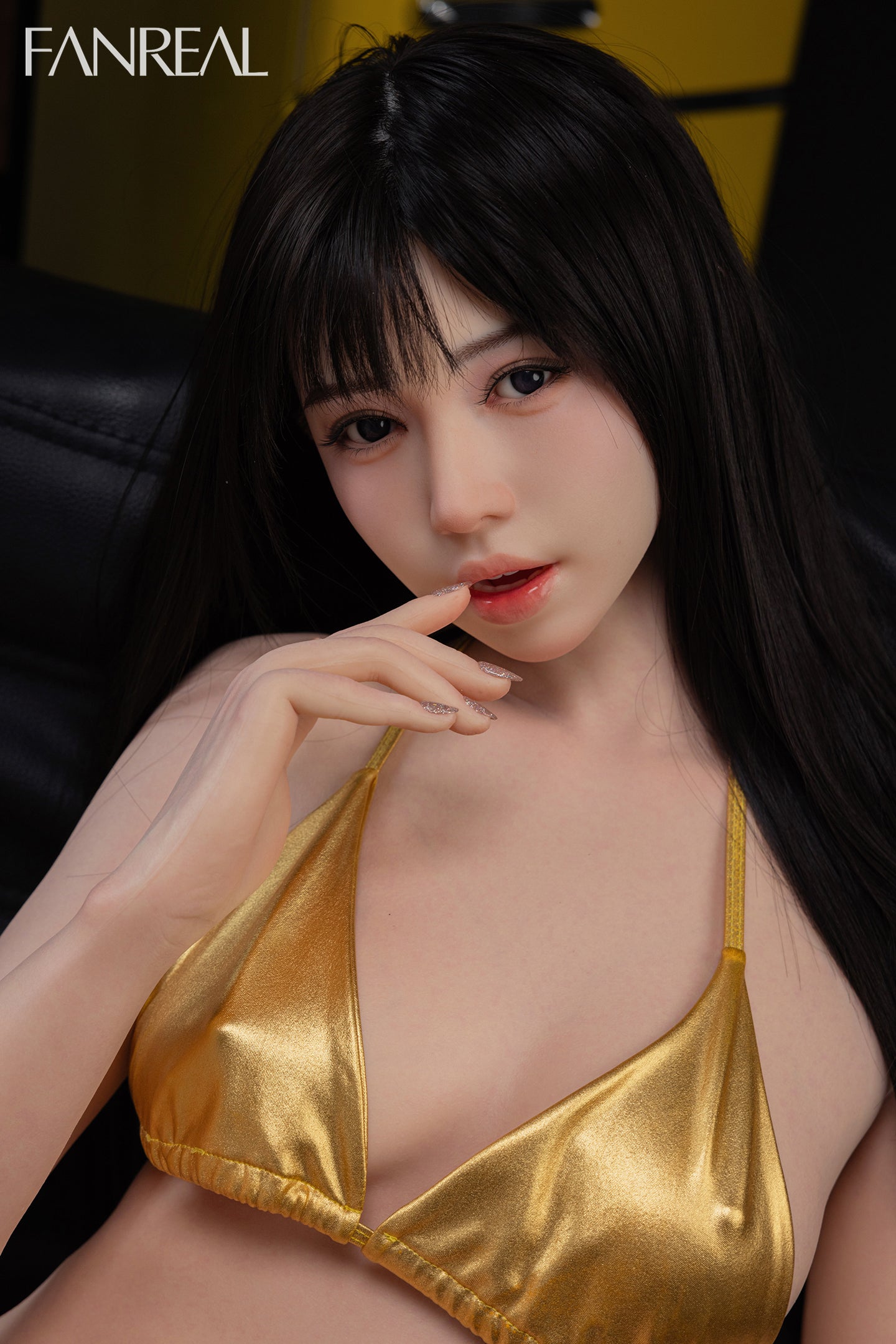 FANREAL DOLL 158 CM B Silicone - Nora V2 wearing a gold bikini top while sitting in a leather couch.