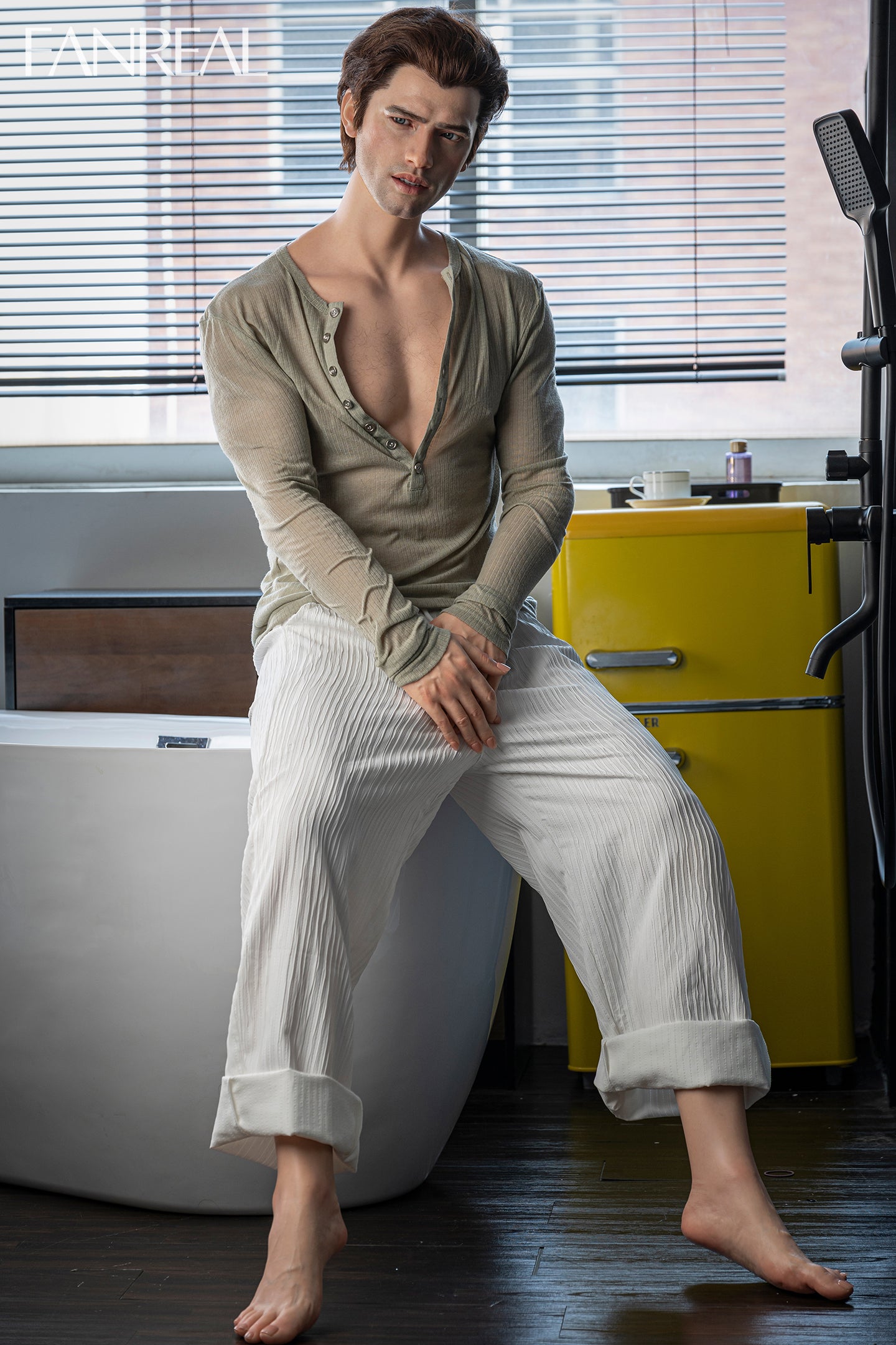 FANREAL DOLL 173 CM Silicone - Male Carter V2 sitting on a bathtub wearing a loose-fitting shirt and pants in a bathroom setting.