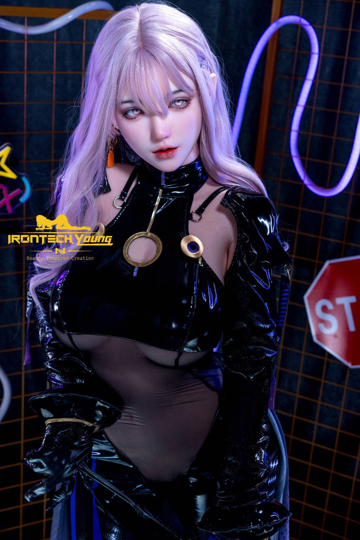 Irontech 165T E Young Series Silicone - Zia – standing in a sleek black latex outfit with sheer panels, posed against a neon-lit grid wall