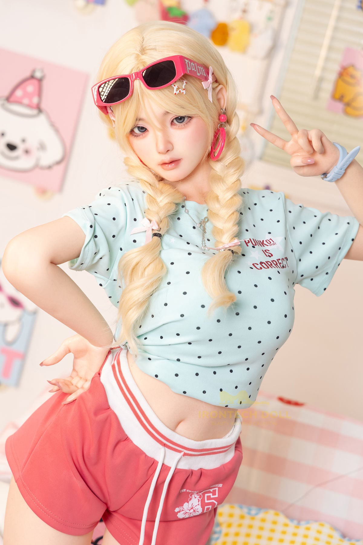 Irontech Doll 148 cm Plus B Silicone - Xia Ying upper body front view in light blue polka dot crop jacket with blonde twin buns, bright kawaii bedroom background