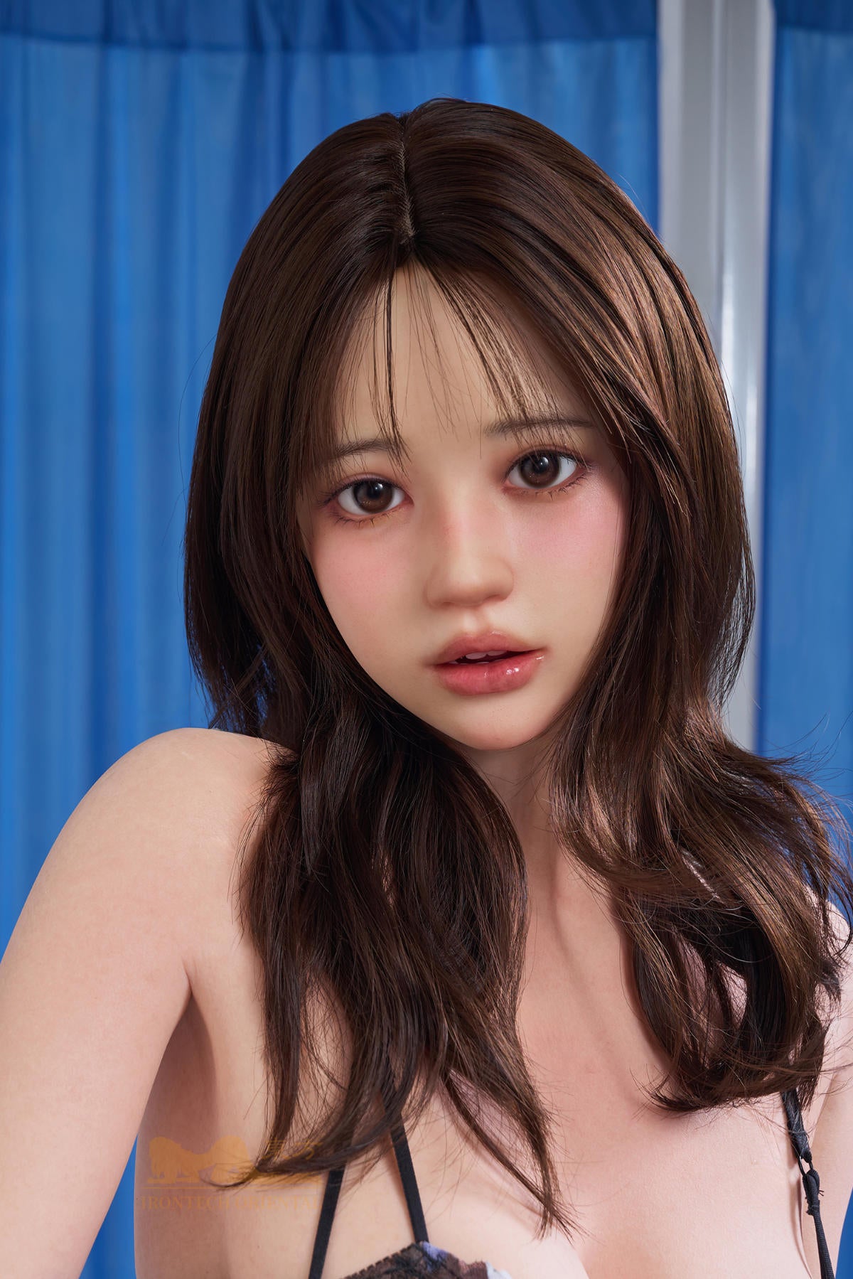 Close-up head and shoulders portrait of the Irontech Doll 151 cm D Oriental Series Silicone – Evie against a blue curtain backdrop.