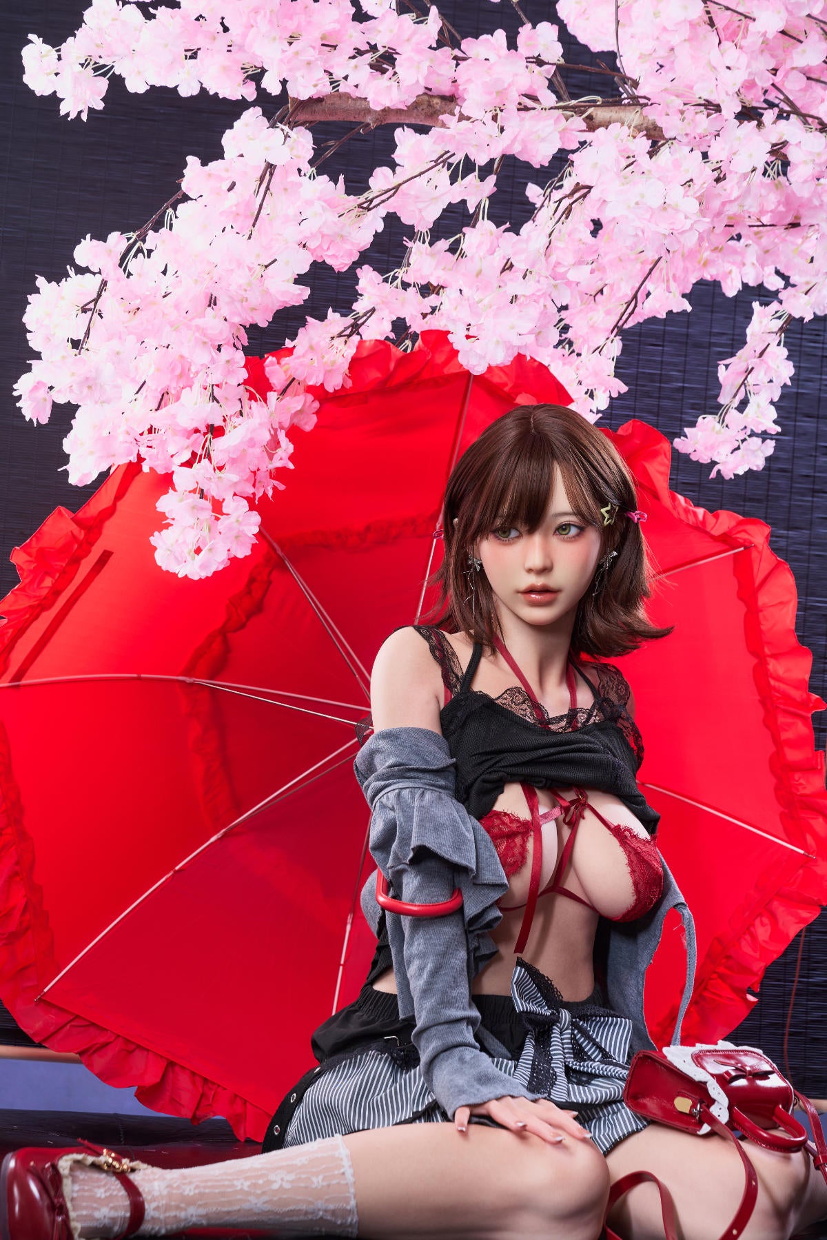 Irontech Doll 151 cm D Oriental Series Silicone – Yuna reclining on the floor next to a red traditional umbrella and pink blossoms.