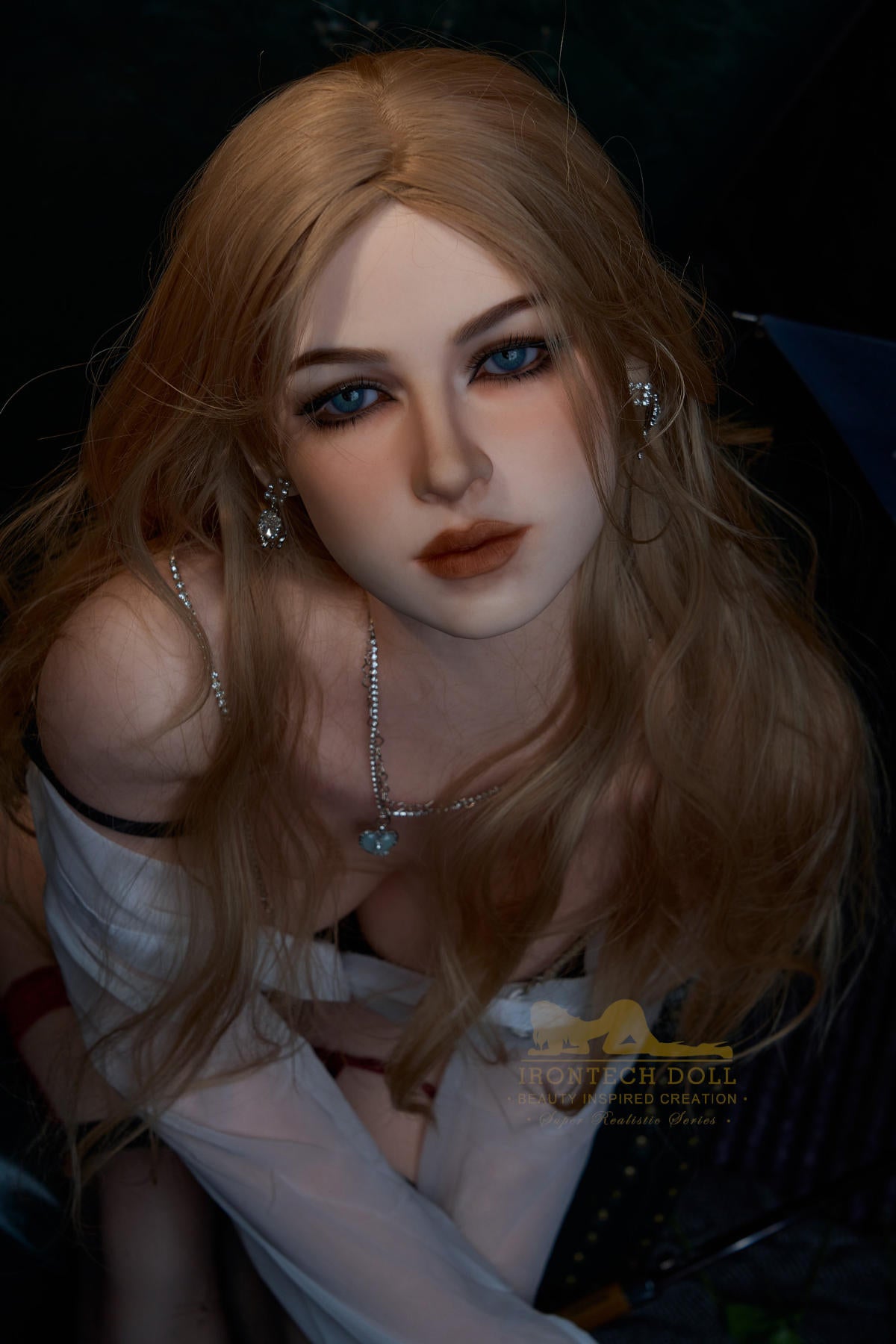 Close-up of Irontech Doll 164 cm E Silicone - Flora with blonde hair and blue eyes, wearing a white top.