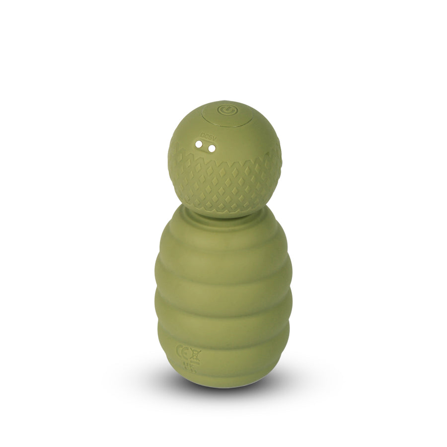 Compact green handheld massager with textured grip and rounded head on white background