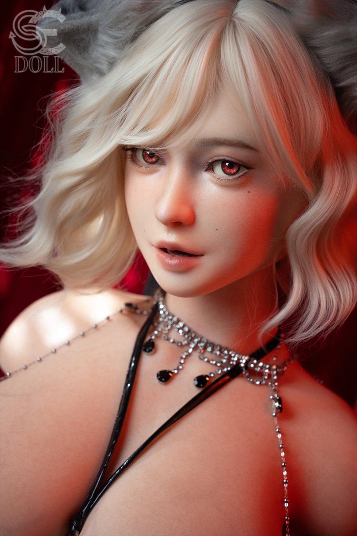 SEDOLL T110 cm J Silicone Torso - Maya.B close-up portrait, platinum blonde wavy hair, delicate layered necklace, bare shoulders, smoky red velvet backdrop