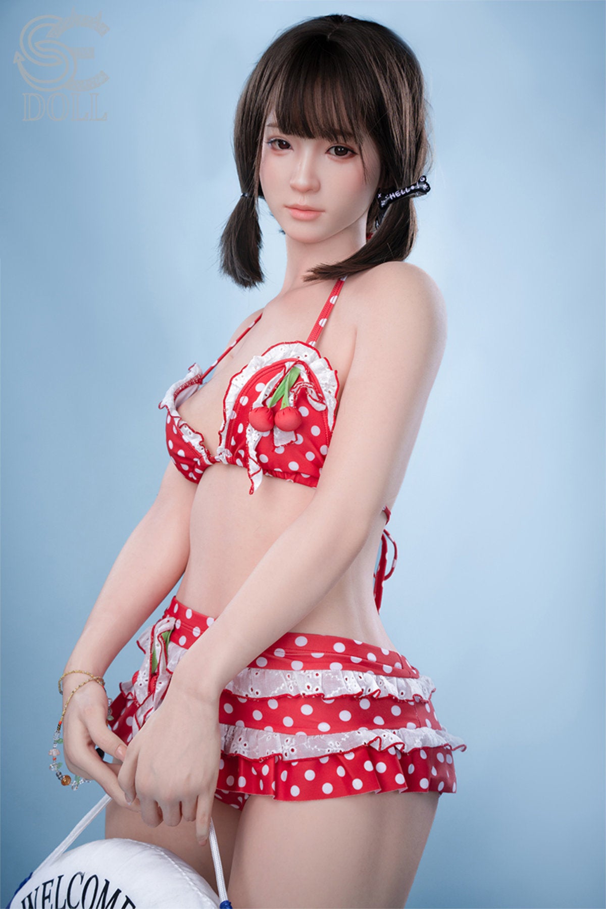 SEDOLL T159cm A Aya Series Silicone - Airi.A – Seated pose on woven basket, red polka-dot bikini bottom, top removed, dark straight-bang hairstyle, light blue backdrop.