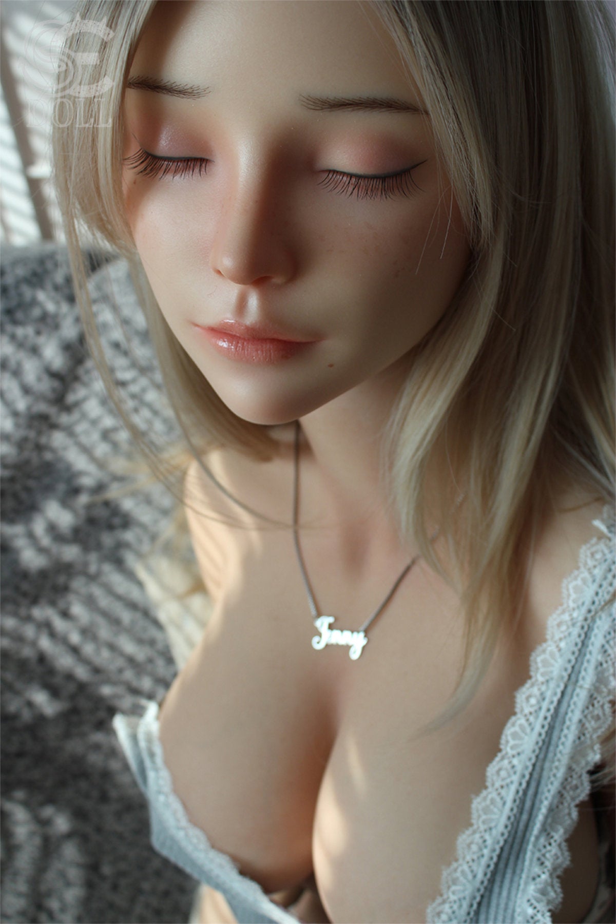SEDOLL T161cm C Silicone Pro - Jenny.O – Close-up pose, light blue plaid top pulled down at the chest, wavy blonde hair framing the face, soft neutral backdrop.
