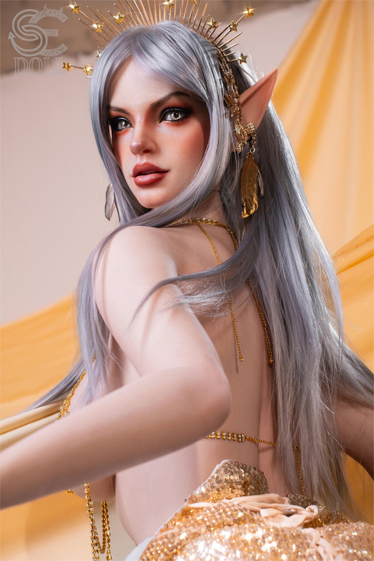 SEDOLL T167 cm E Silicone Pro - Evadora.A close-up with one bare shoulder exposed, long silver hair cascading past her collarbone, silver spiked headpiece, warm gold silk backdrop