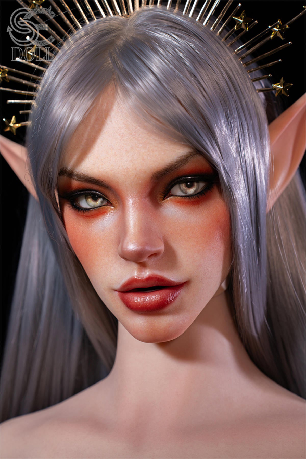 SEDOLL T167 cm E Silicone Pro - Evadora.A close-up portrait against a soft plain backdrop, silver spiked headpiece, long silver hair framing a calm, direct expression