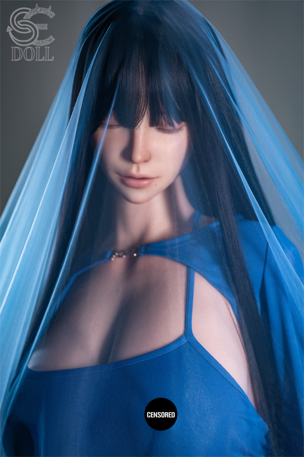 Medium shot of SEDOLL T111 cm G Silicone Torso - Jenny.O looking downward, partially covered by a transparent blue mesh veil that creates a soft, cinematic lighting effect.