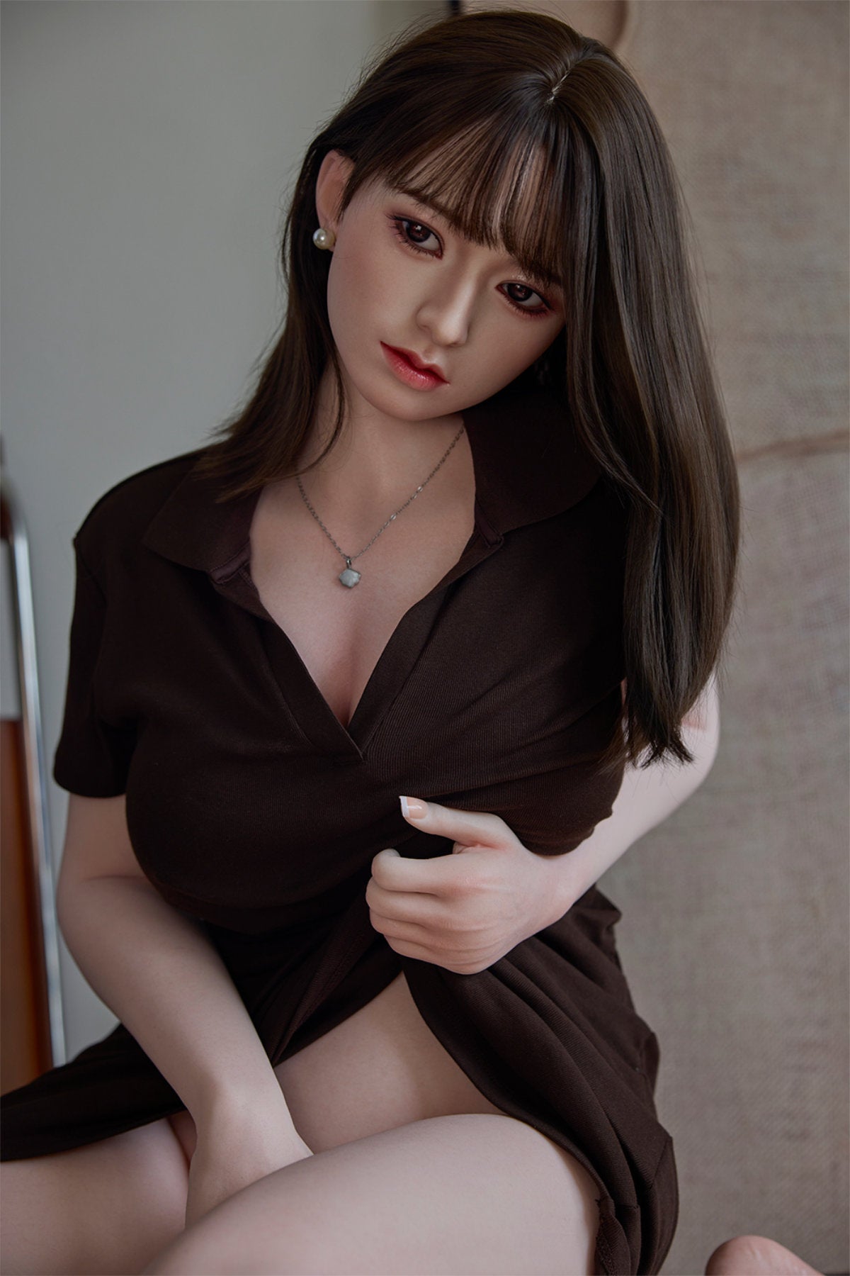 Starpery 154cm E - Yuan – Standing pose beside wooden furniture, brown top partially unbuttoned, dark straight-bang hairstyle, rustic wood backdrop.